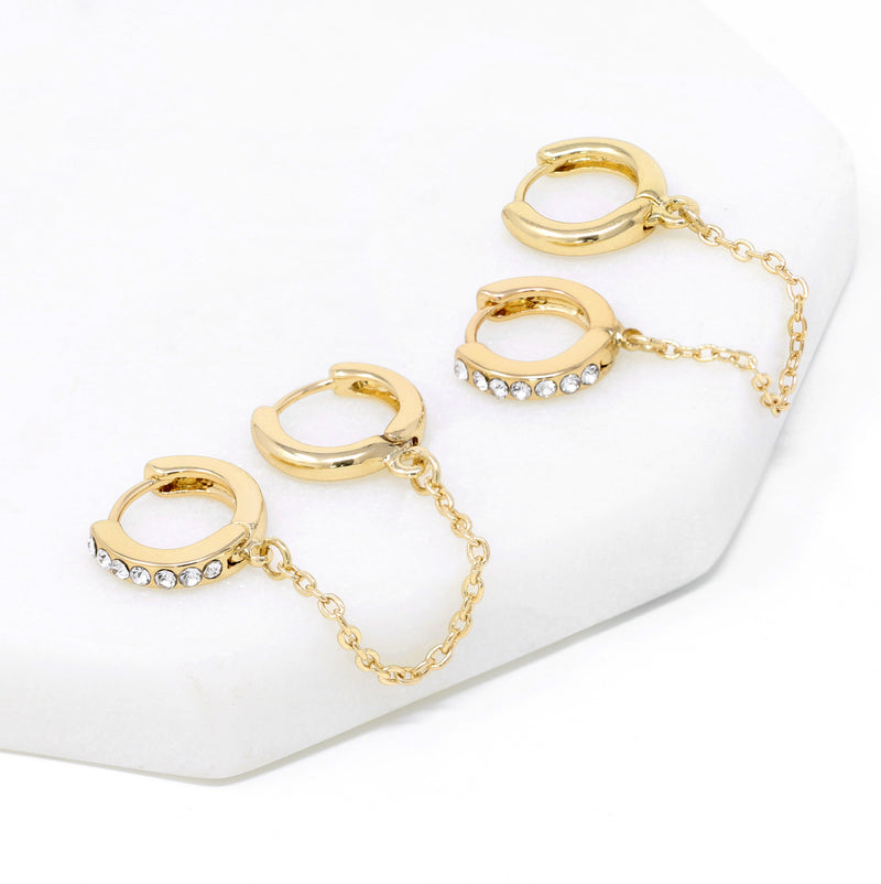 Paved modern loop earplug earrings in gold connected with chains.