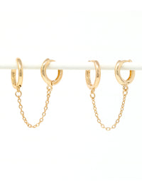 Gold hoop earrings with chains on a white background