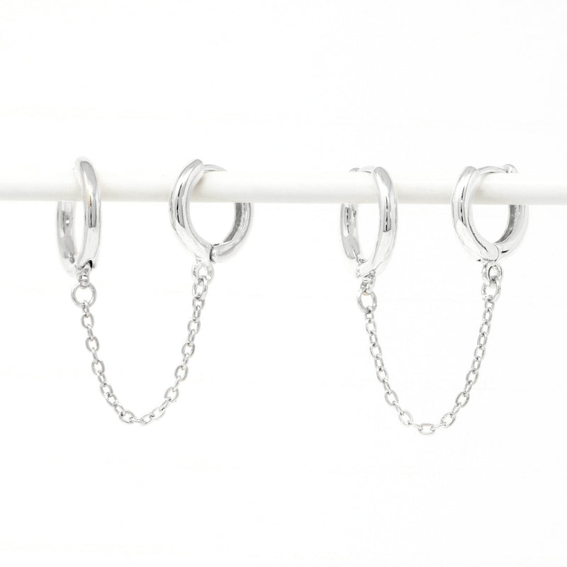 Modern loop earplug earrings in silver, connected with chains.
