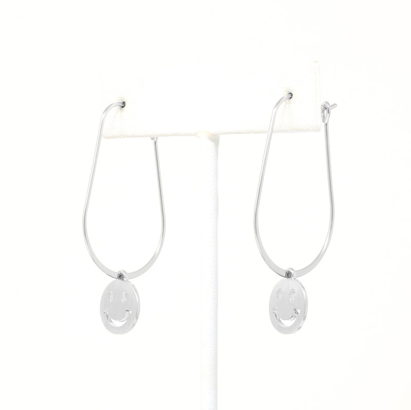 A pair of smiley face charmed teardrop hoop earrings in silver.