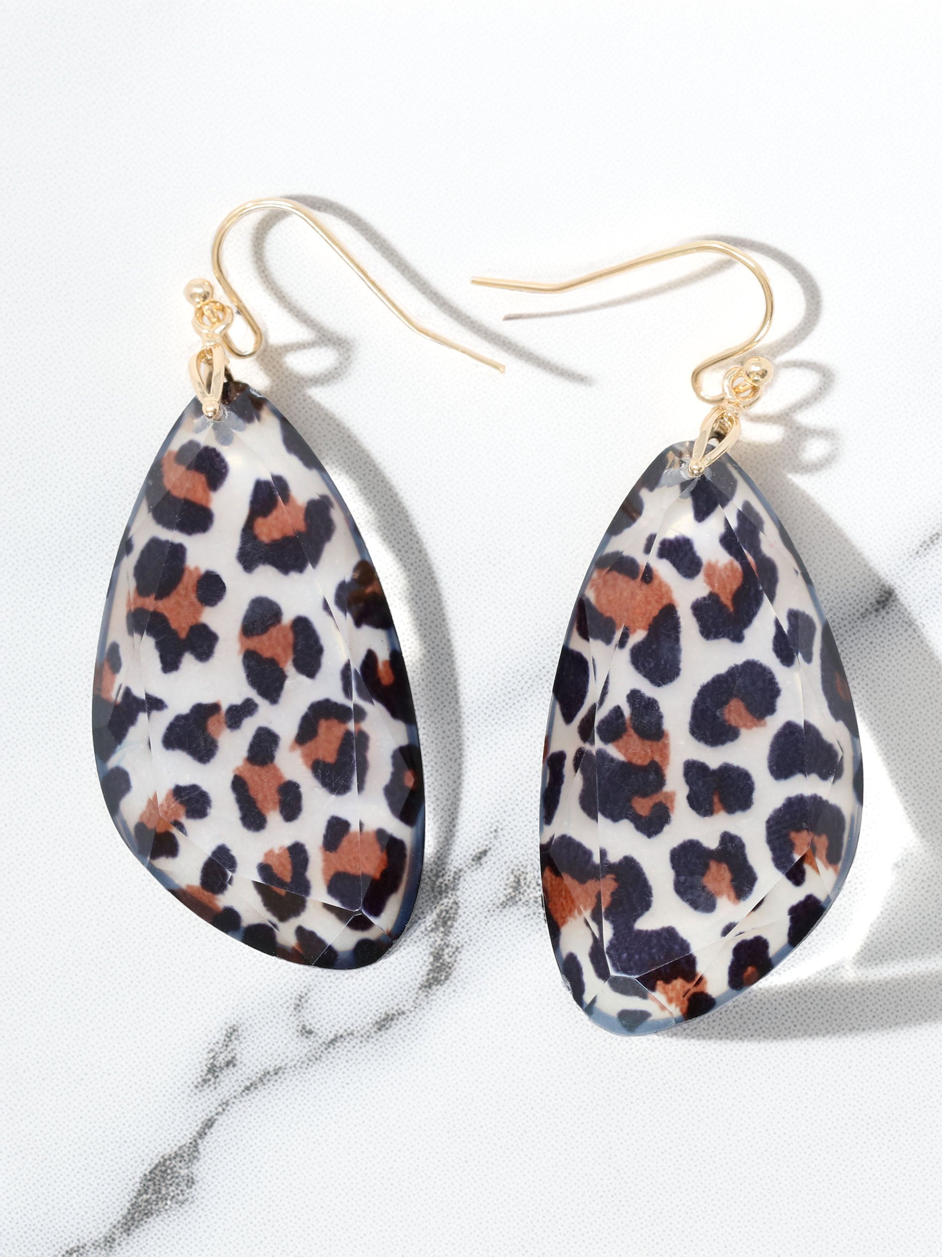 Leopard print earrings on a marble background