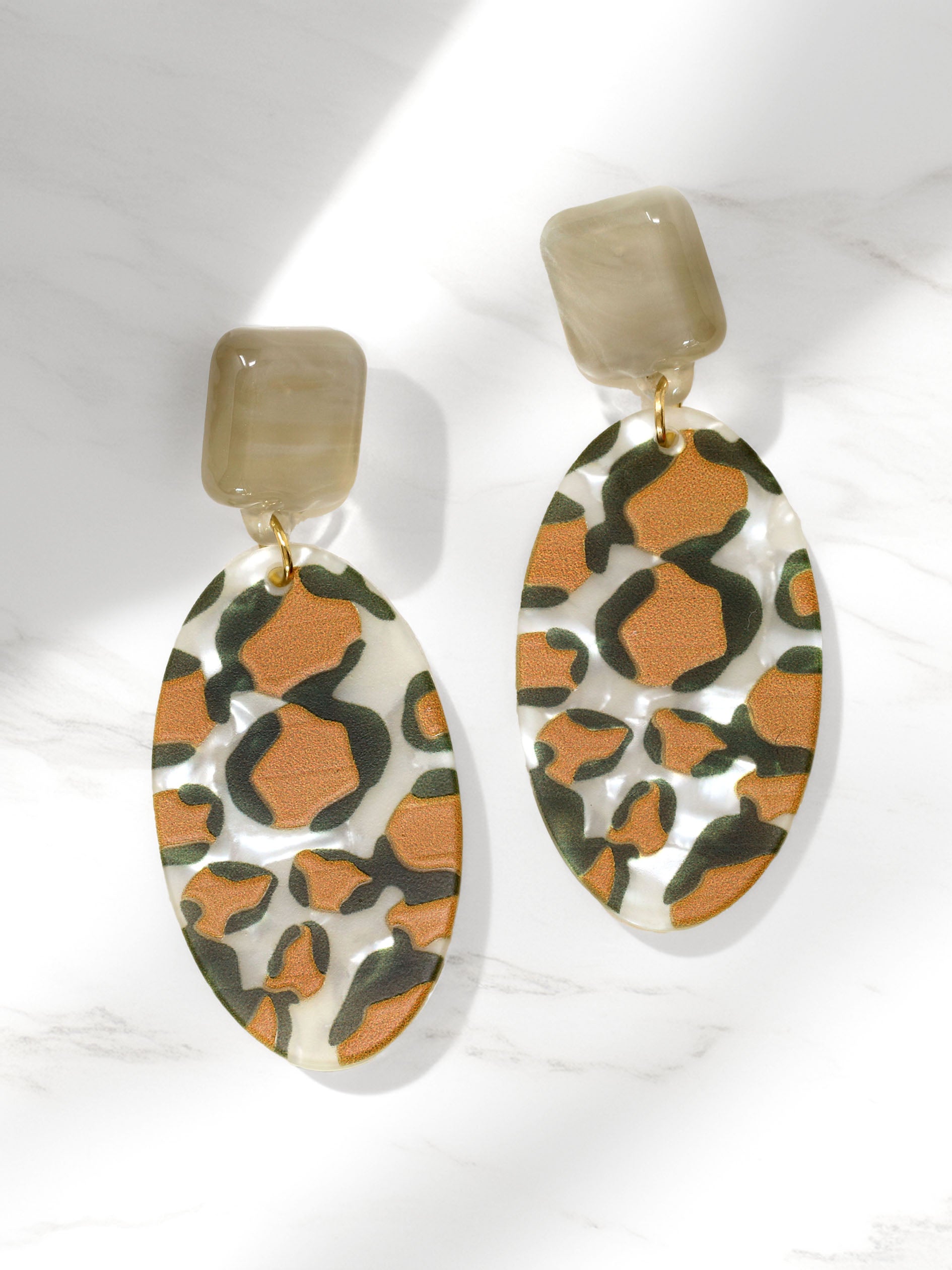 Pair of earrings with a leopard print design on a white background