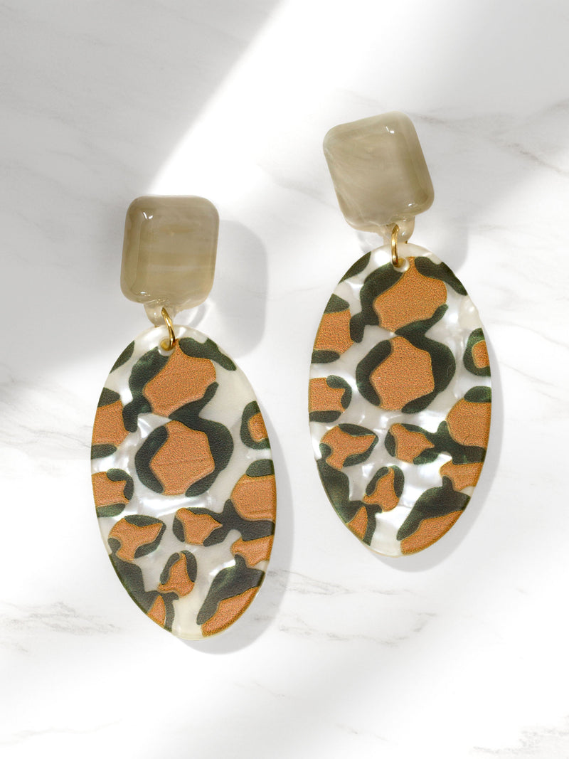 Pair of earrings with a leopard print design on a white background