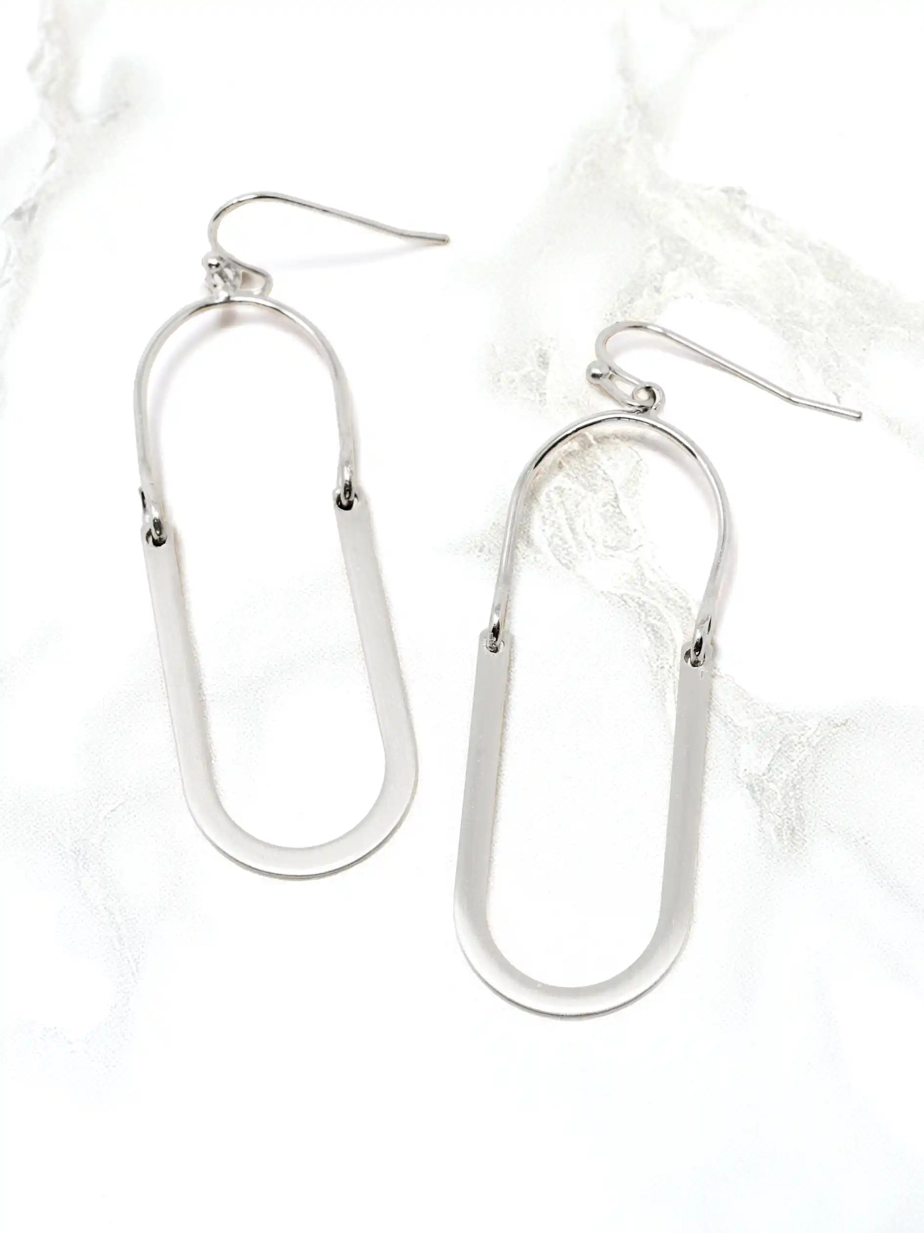 Silver u-shape metal drop and dangle earrings on a white background