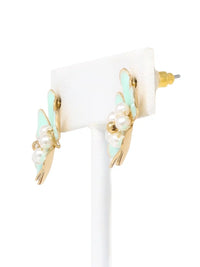 Pair of earrings with gold, pearl, and turquoise accents on a white background