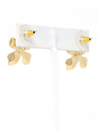 Pair of gold propeller earrings on a white background