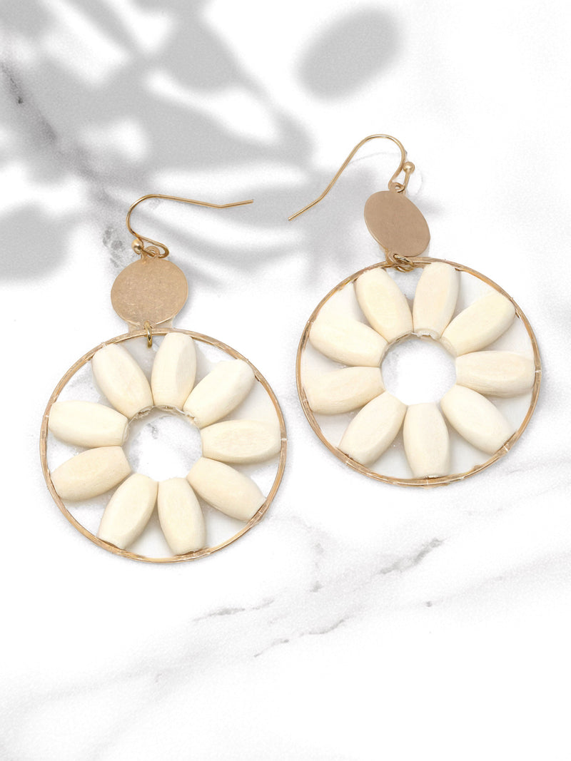 Pair of earrings with white circular designs on a light background