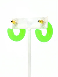 A pair of neon green colored resin hoop earrings with a bold rounded 25mm design.
