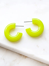 A pair of neon yellow colored resin hoop earrings with a bold rounded 25mm design.