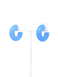 A pair of tranquil blue colored resin hoop earrings with a bold rounded 25mm design.