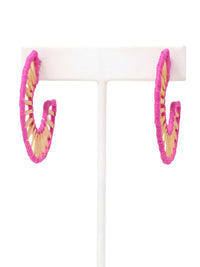 Bright pink and natural wood spiral hoop earrings displayed on a white T-stand against a white background.