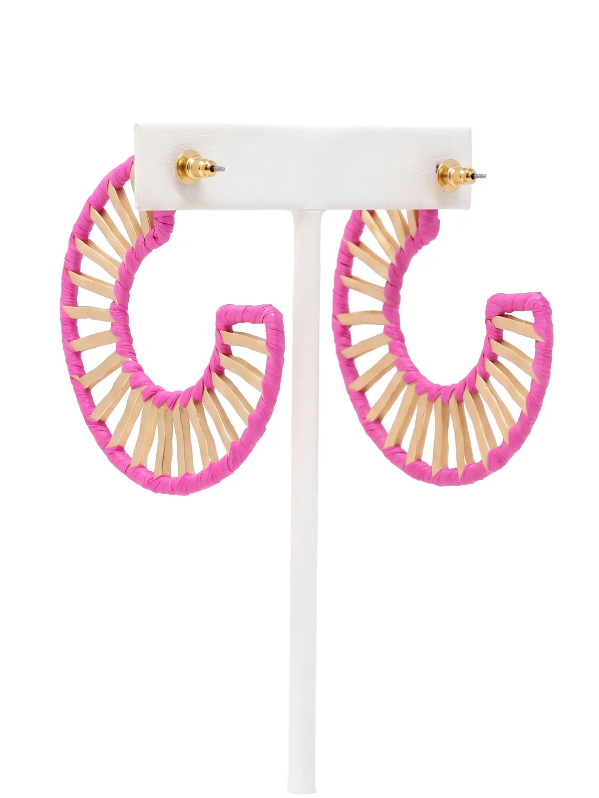 A pair of large crescent-shaped hoop earrings with a bright pink outer layer and a central ring made of natural wood matchsticks, displayed on a white T-stand against a white background.