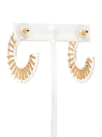 White and beige fringe hoop earrings displayed on a clear acrylic stand against a white background.