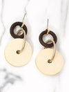 Pair of earrings with gold and brown circular designs on a marble background