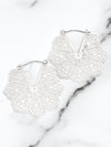 White lace-style earrings on a marble surface