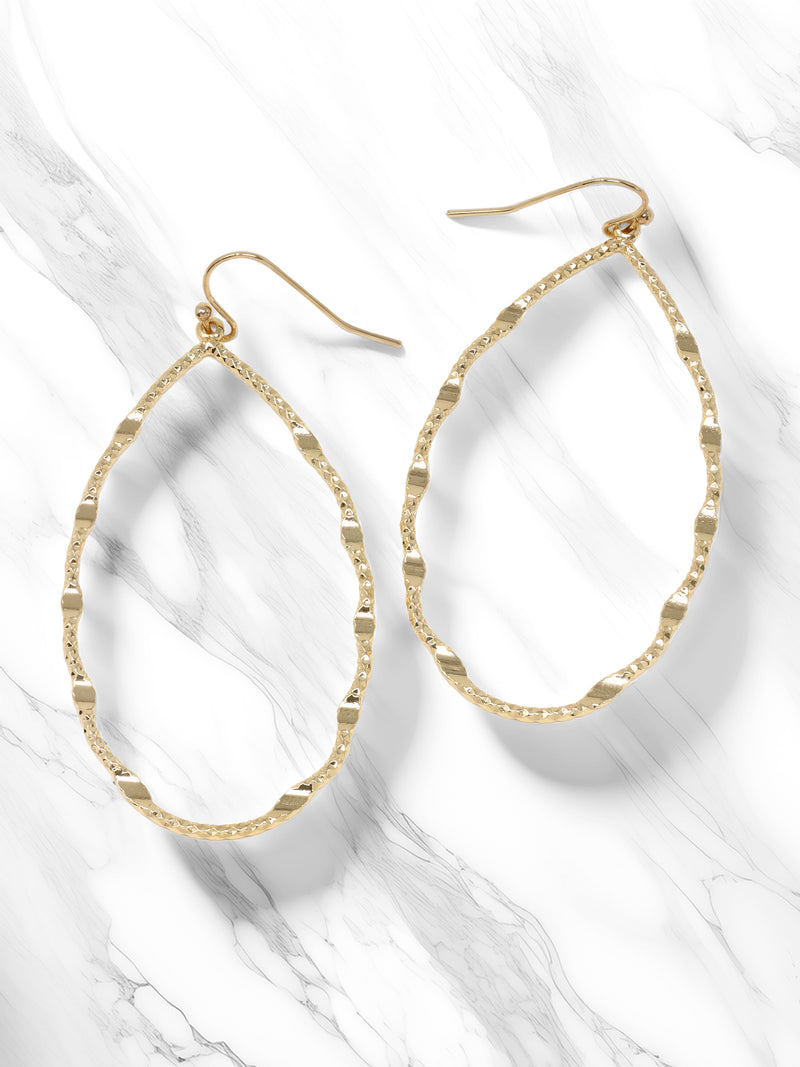 A pair of teardrop-shaped dangle earrings with a textured, hammered finish, attached to delicate hooks for a lightweight and elegant statement.