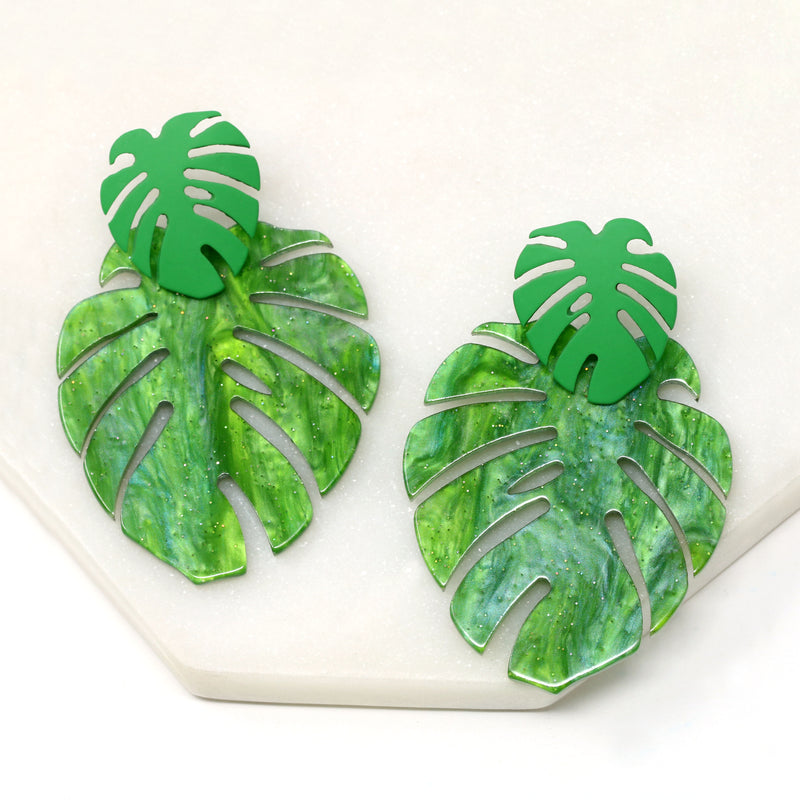 A pair of drop and dangle earrings featuring tropical green leaf resin, adding a vibrant touch to your style.