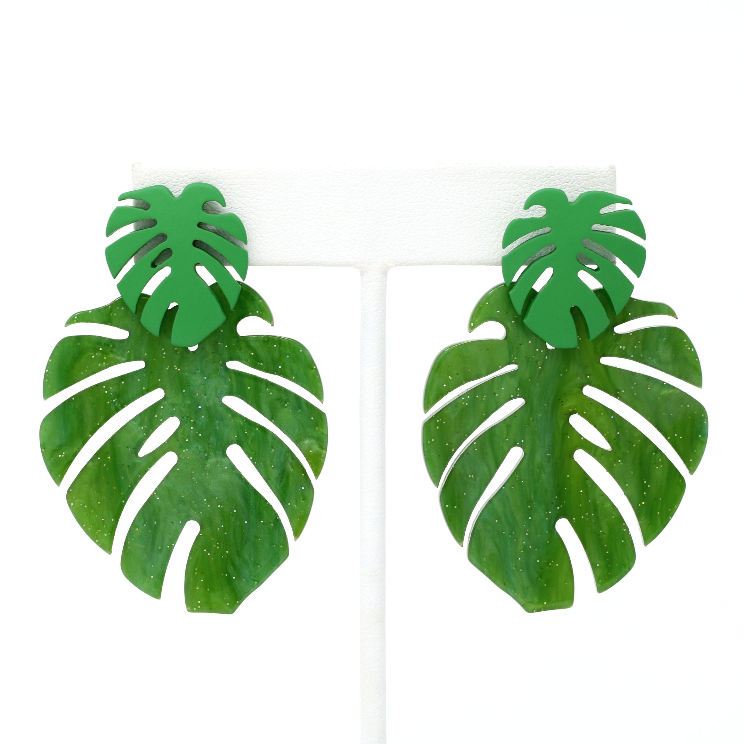 A pair of drop and dangle earrings featuring tropical green leaf resin, adding a vibrant touch to your style.