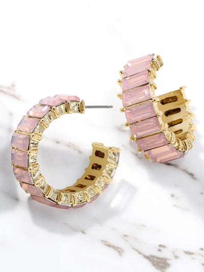 Pink hoop earrings with gold accents on a marble surface