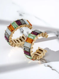 Gold bracelet with multicolored glass stones on a light background
