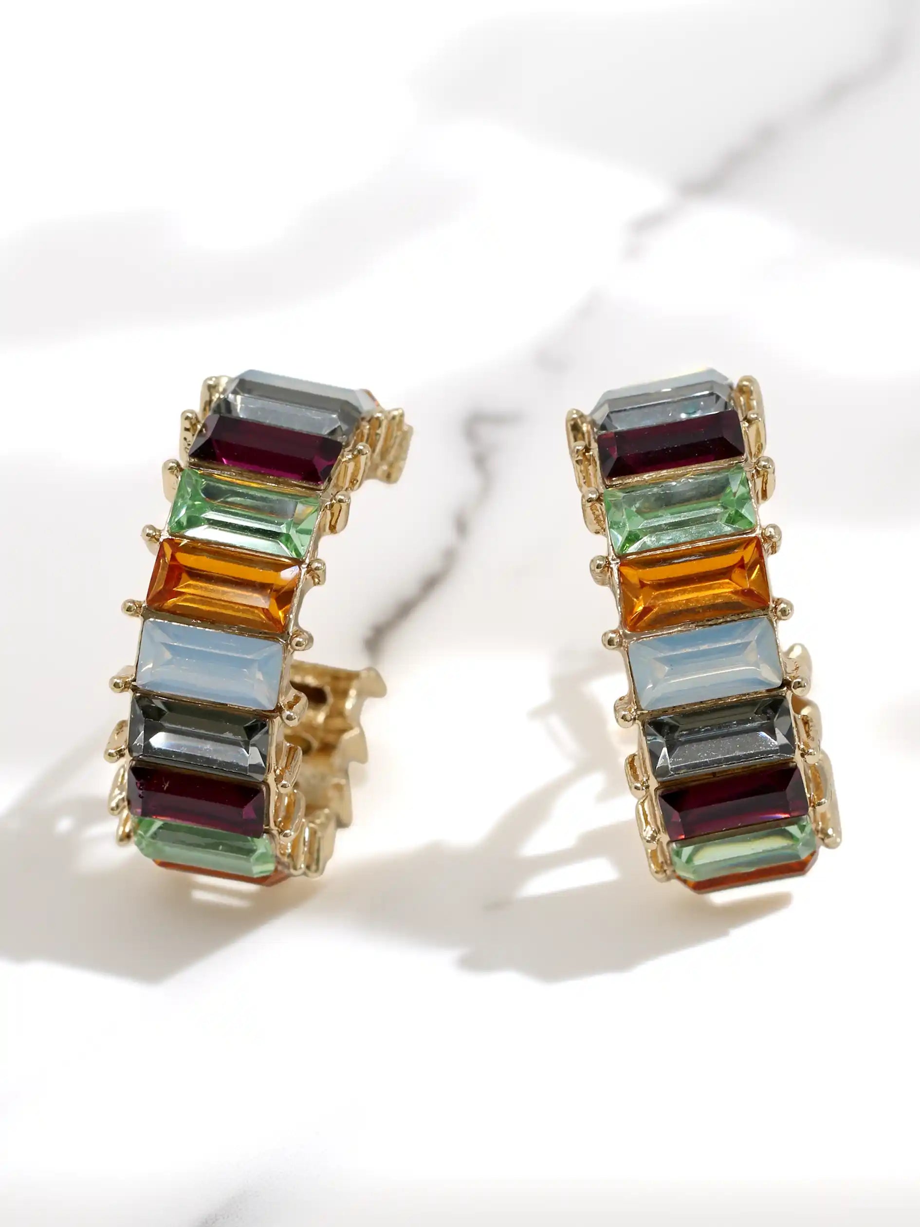 Multicolored glass stone earrings on a white background