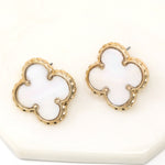 A pair of quatrefoil natural shell stud earrings in gold.