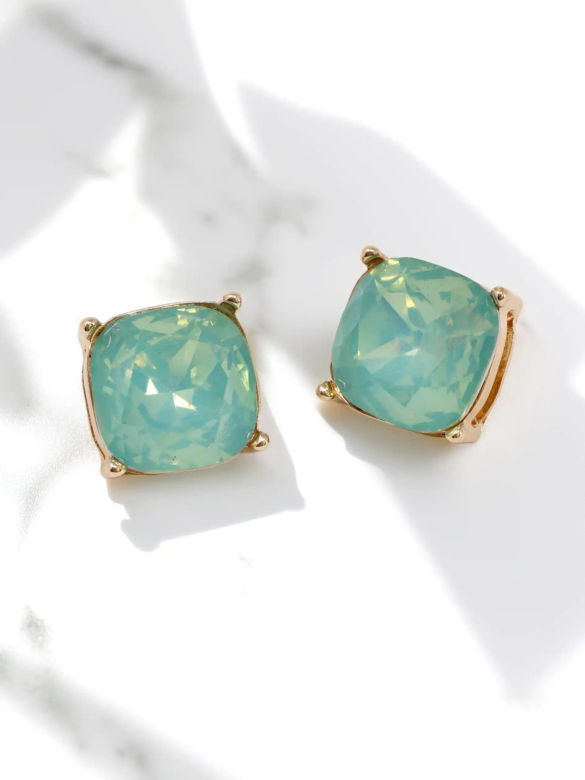 Pair of mint opal stud earrings on a white background
