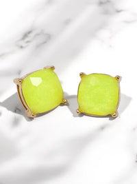 Pair of neon green earrings on a light marble background