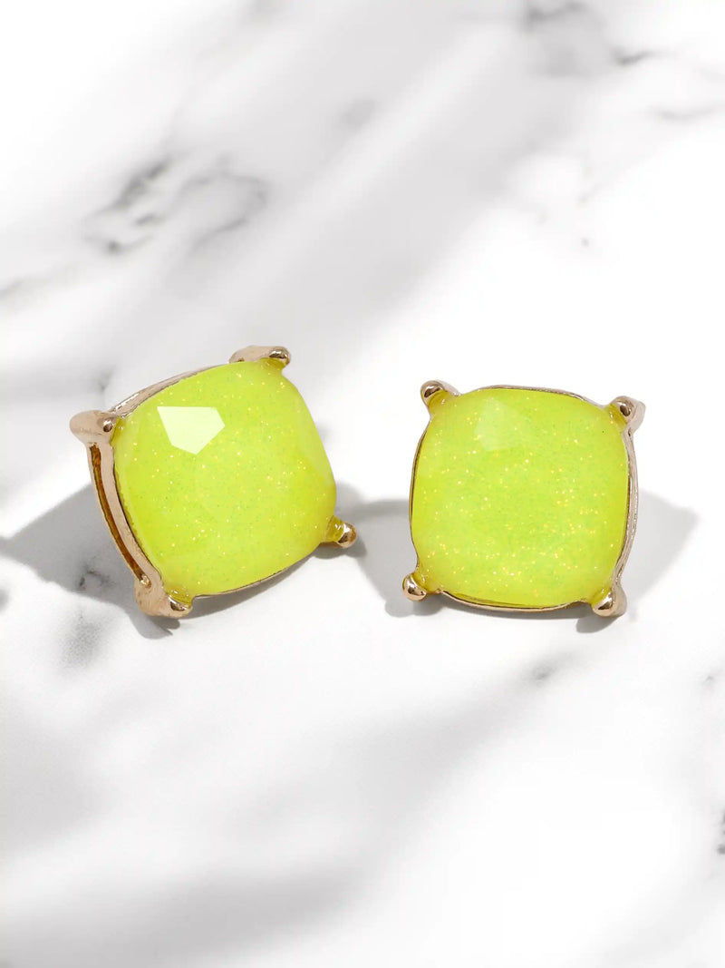 Pair of neon green earrings on a light marble background