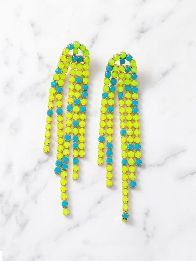 Overhead shot of a pair of long, cascading duster earrings featuring tiered strands of vibrant neon yellow-green and bright turquoise-blue faceted beads set in gold-tone metal. The earrings are lying flat on a white marble surface.