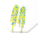 A pair of neon yellow colored stone chain shoulder duster earrings.