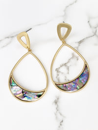 Gold teardrop earrings with colorful gemstones on a marble surface