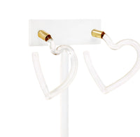 A pari of heart shaped hoop earrings feature a sleek and polished transparent resin that catches the light beautifully.