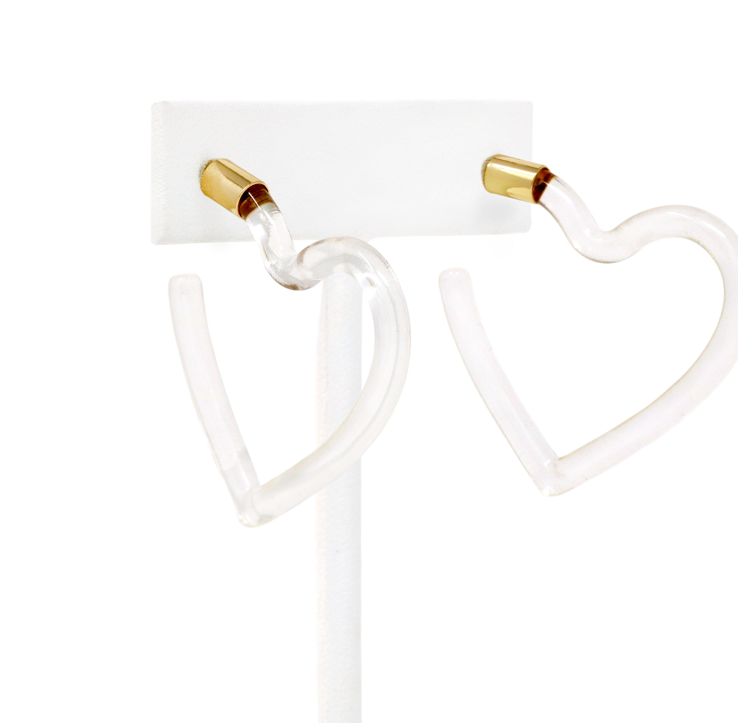 A pari of heart shaped hoop earrings feature a sleek and polished transparent resin that catches the light beautifully.