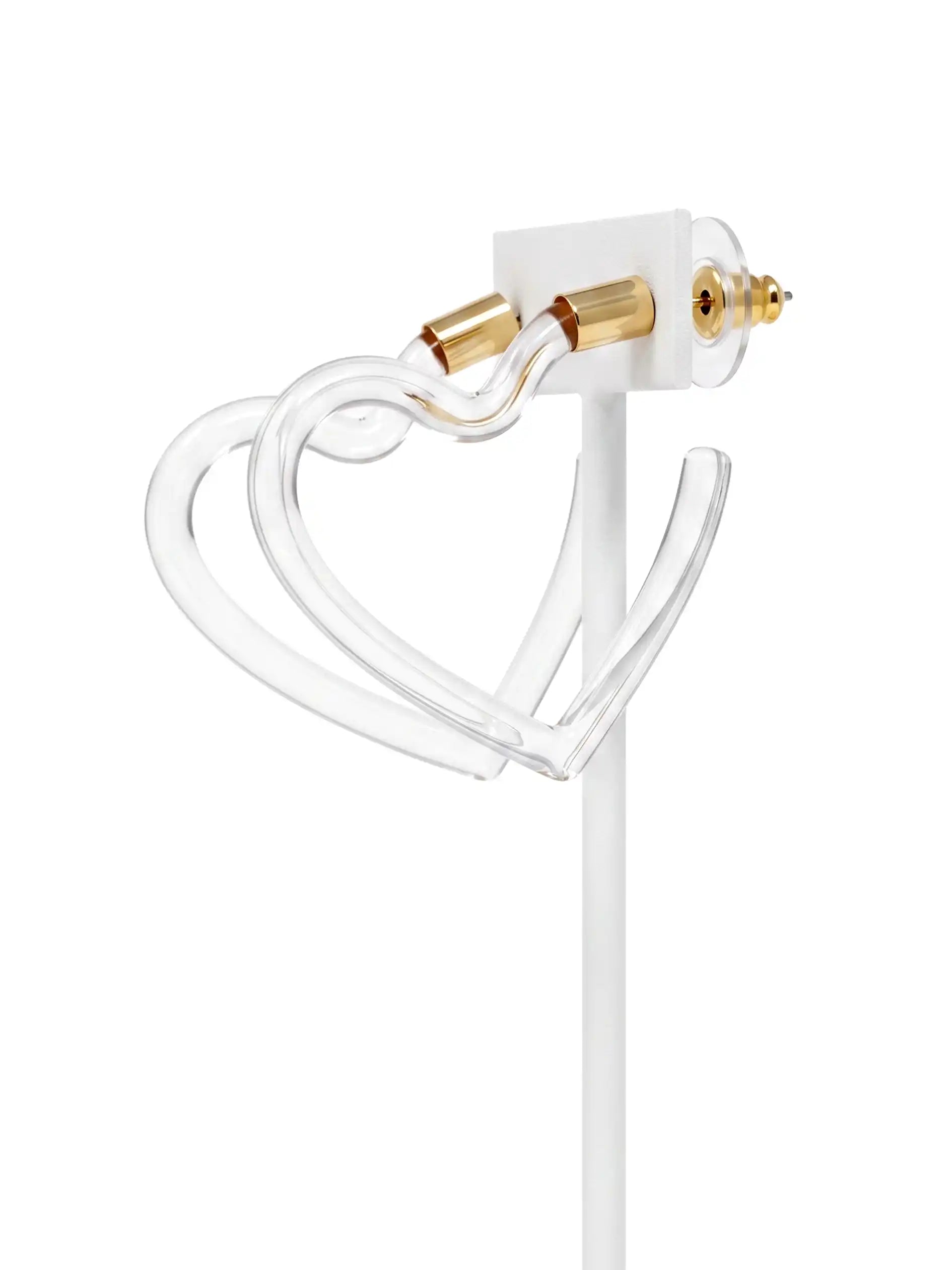 A clear acrylic heart-shaped necklace with gold-tone hardware and a white display stand, shown against a solid white background.