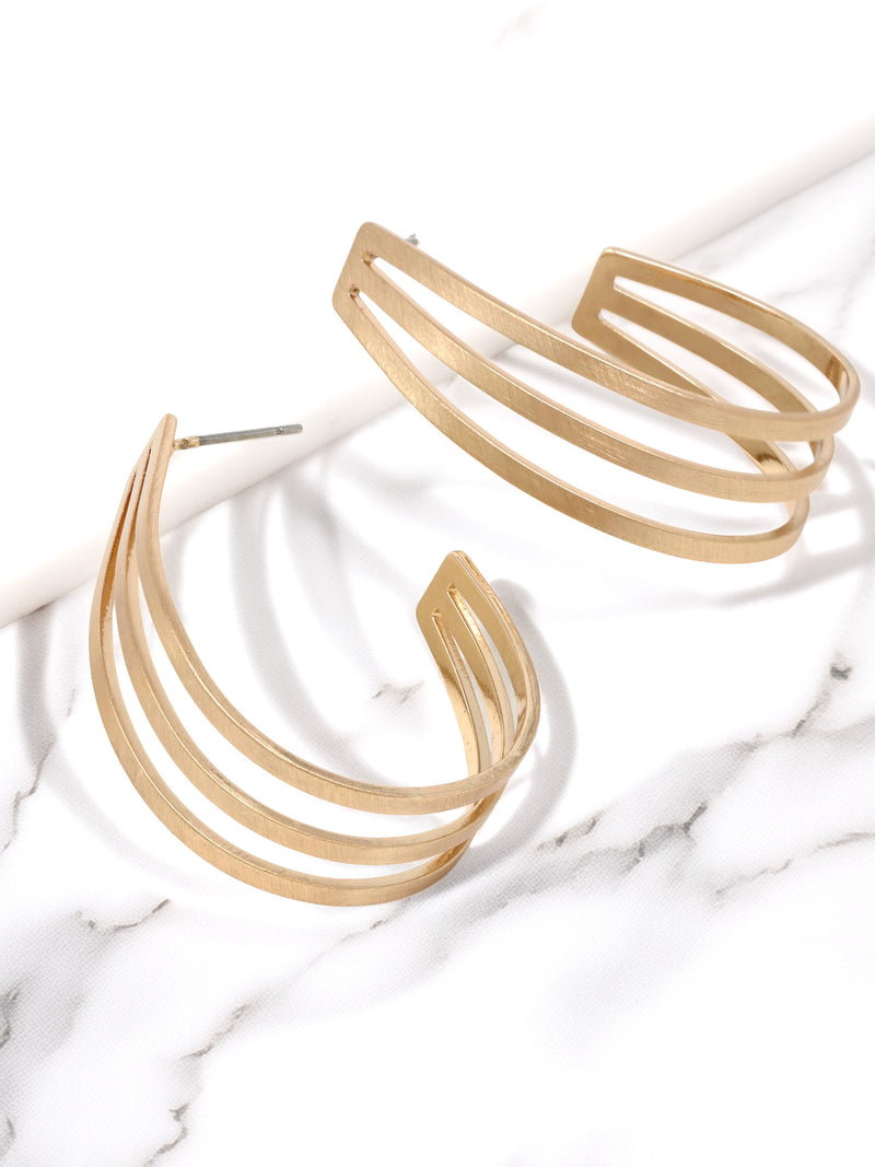 Gold hoop earrings on a marble surface
