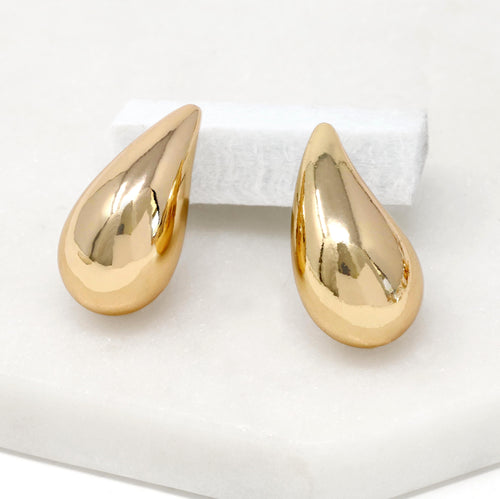 A close-up of gold puffy teardrop hollow bold earrings, showcasing their modern and minimalist design. The earrings make a statement with their sleek metal construction and distinctive shape.