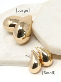 Two pairs of gold teardrop-shaped stud earrings displayed on a white marble surface, labeled [Large] and [Small] to show scale.