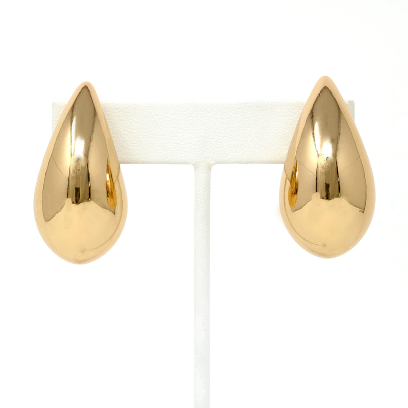 A close-up of gold puffy teardrop hollow bold earrings, showcasing their modern and minimalist design. The earrings make a statement with their sleek metal construction and distinctive shape.