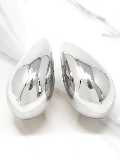 A pair of polished silver teardrop-shaped wall art pieces with a highly reflective metallic finish, displayed on a white marble surface.