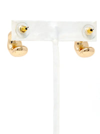 A pair of gold hoop earrings displayed on a white jewelry stand against a white background.