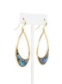 A pair of gold teardrop dangle earrings with iridescent abalone shell inlays, displayed on a white stand against a white background.