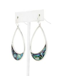 A pair of silver teardrop dangle earrings with iridescent abalone shell inlays, displayed on a white stand against a white background.
