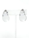 A pair of clear resin teardrop-shaped stud earrings with silver-toned caps, showcasing their smooth, glossy finish and minimalist design.