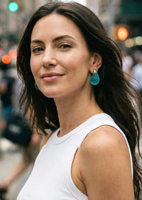 Woman wearing turquoise earrings in an urban setting