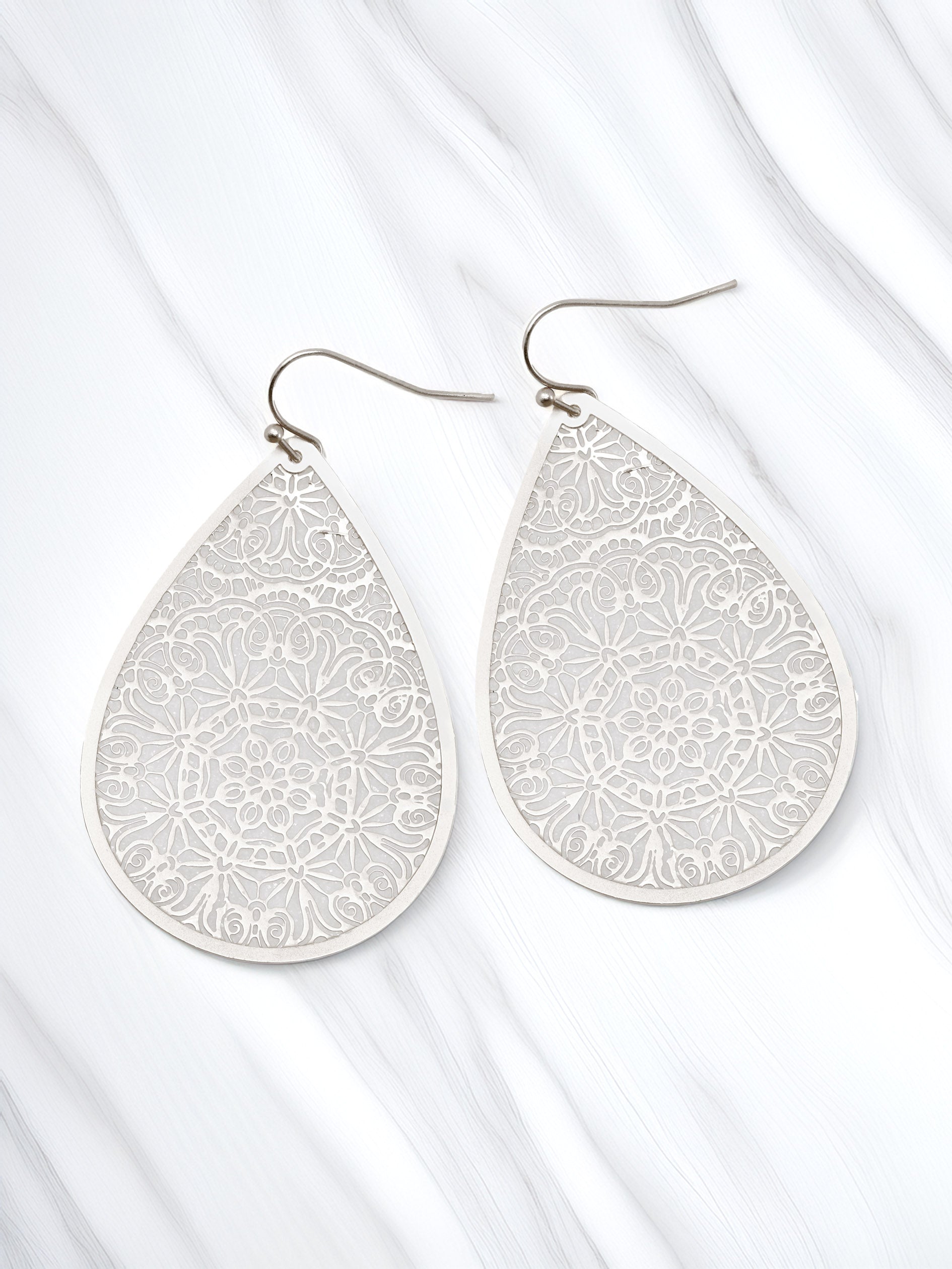 Teardrop-shaped earrings with floral patterns on a white background