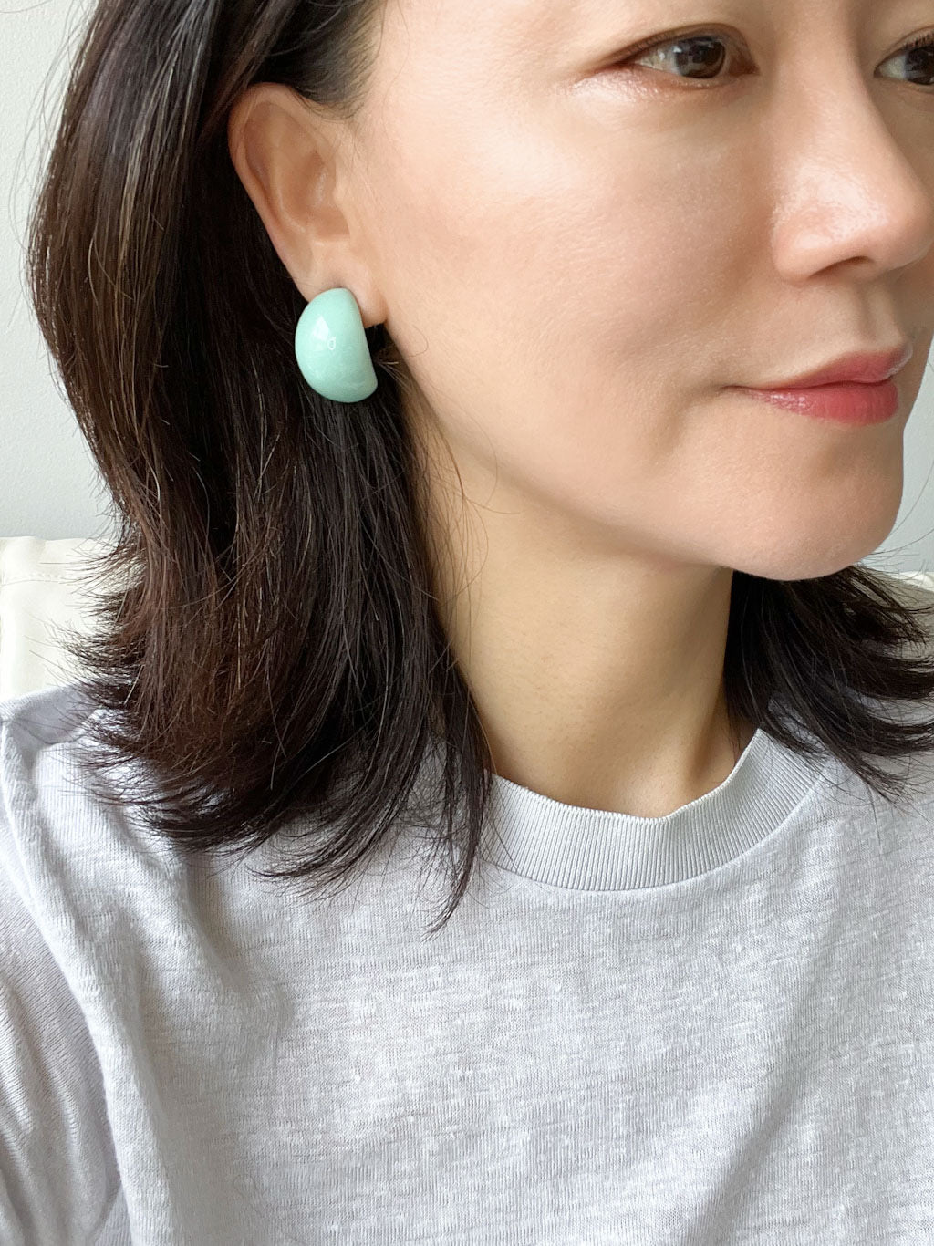 A pair of bold, puffy mint green resin hoop earrings.