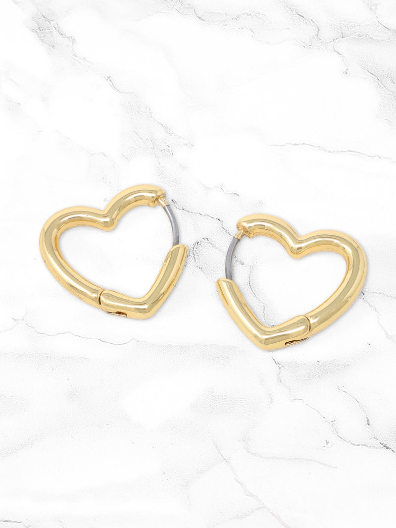 A pair of gold open heart huggie hoop earrings displayed on a marble background, featuring a sleek and polished finish with a hinged closure.
