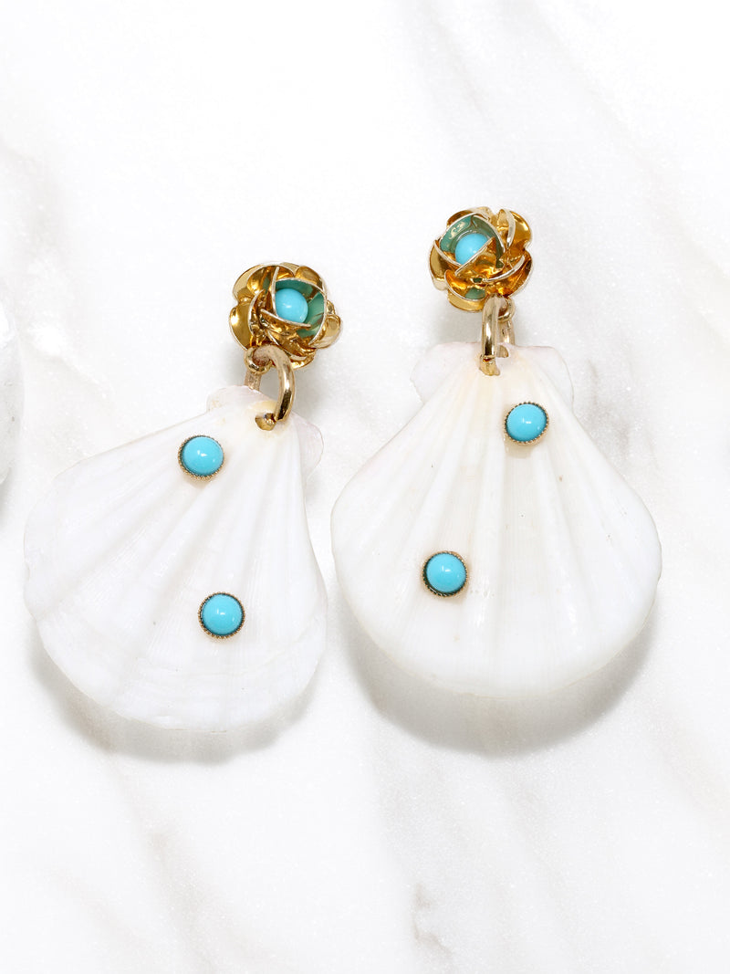 A pair of white natural shell drop earrings featuring turquoise accent stones and gold floral studs.
