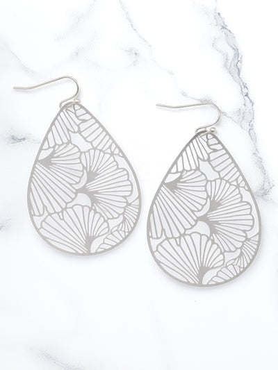 Teardrop-shaped silver earrings with intricate patterns on a white background
